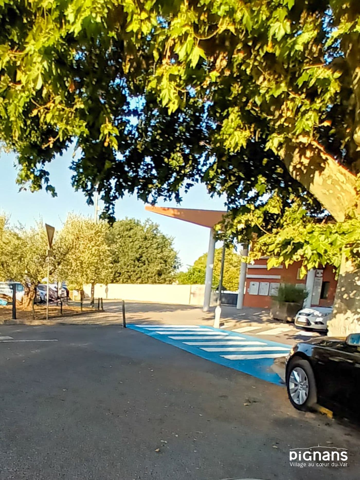 une rue avec des voitures garées sur le côté et des arbres sur le côté