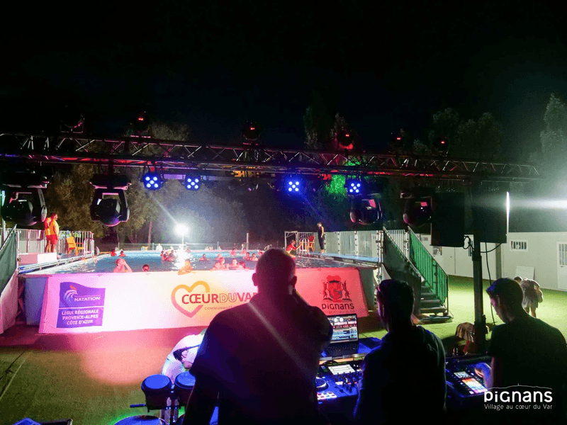 dj de dos avec la piscine de Pignans plage en fond le soir de la pool party